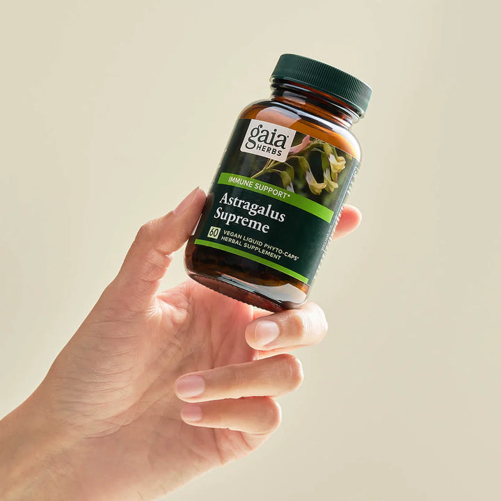 Gaia Herbs 3-in-1 Immune Support 60 Caps in hand, featuring Astragalus Supreme for immune support and stress relief.