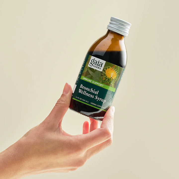 Gaia Herbs Bronchial Wellness Syrup 5.4 Fl Oz held in hand for respiratory support.