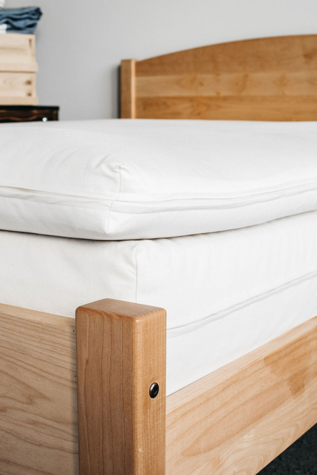 Holy Lamb Wool and Latex Mattress Topper on a wooden bed frame, showcasing its luxurious design and comfort.