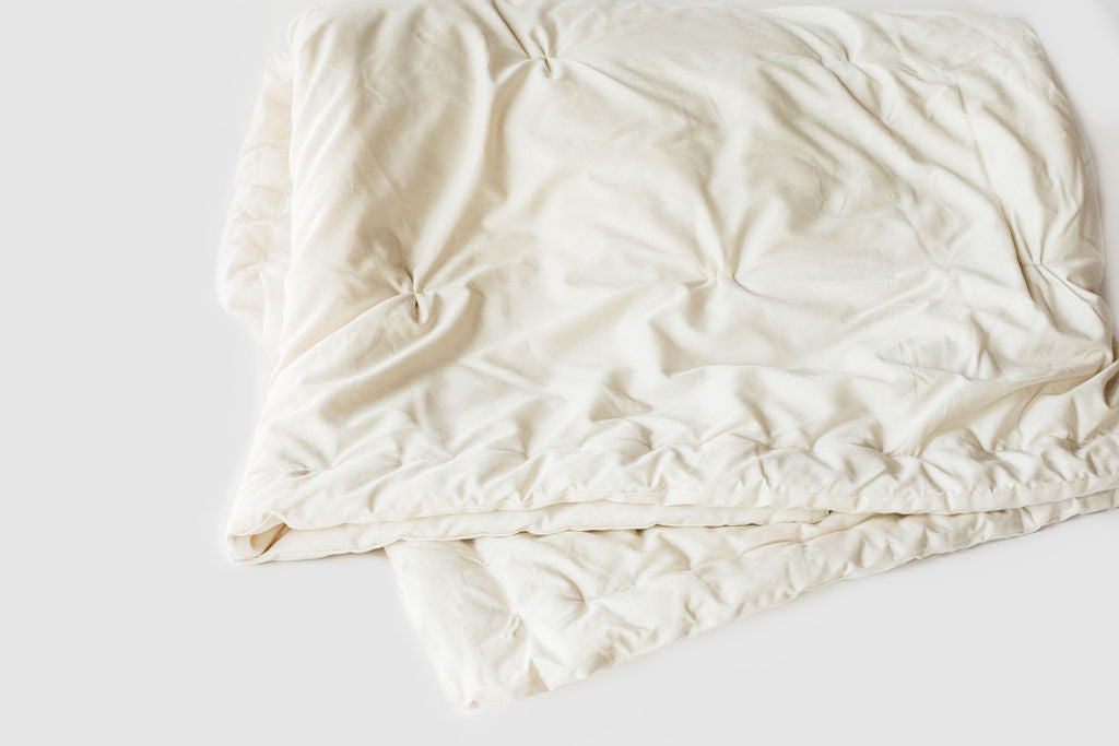 Holy Lamb Organics Wool Comforter shown in a soft, natural color, perfect for a cozy Twin bed, measuring 68” x 86”.
