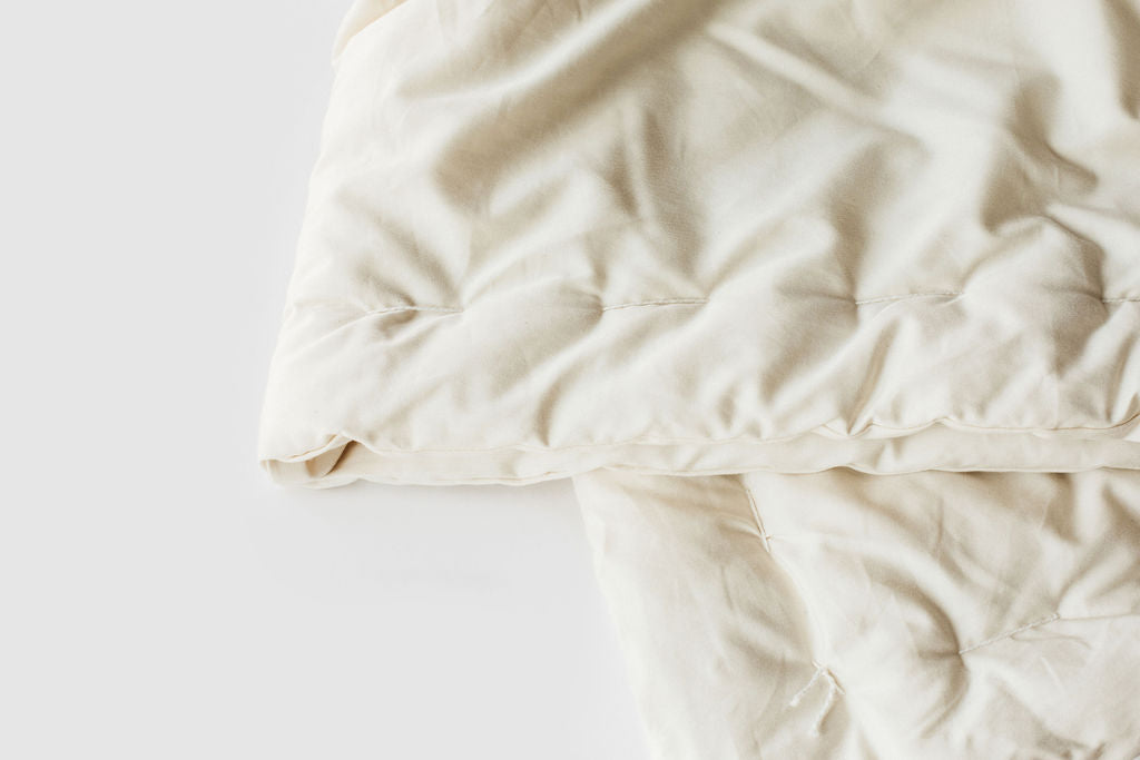 Holy Lamb Organics Wool Comforter in natural fabric, showcasing its cozy design and quality craftsmanship.