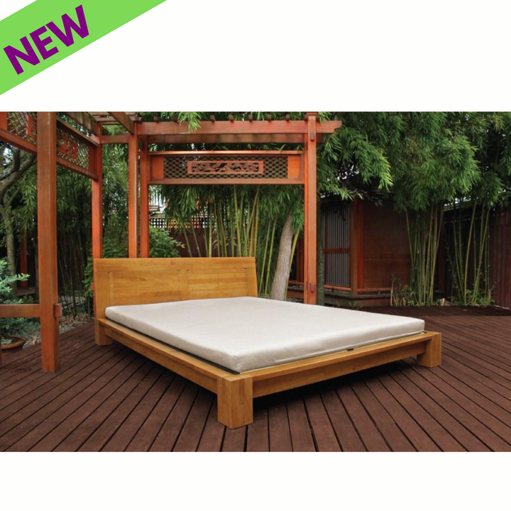 Soaring Heart Organic Latex Shikibuton Full on a wooden bed frame in a serene outdoor setting with a new label.
