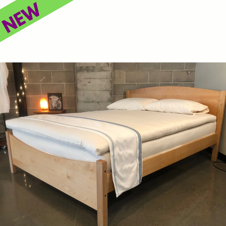 Holy Lamb Wool and Latex Mattress Topper on a modern wooden bed frame, showcasing comfort and eco-friendliness.