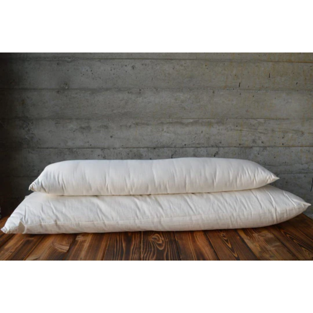 Holy Lamb Organics Body Size Pillows With Case eco-friendly pillows stacked on a wooden surface.