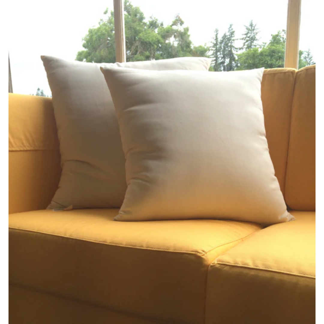 Holy Lamb Organics Throw Pillows on a yellow couch, showcasing natural comfort and stylish design.