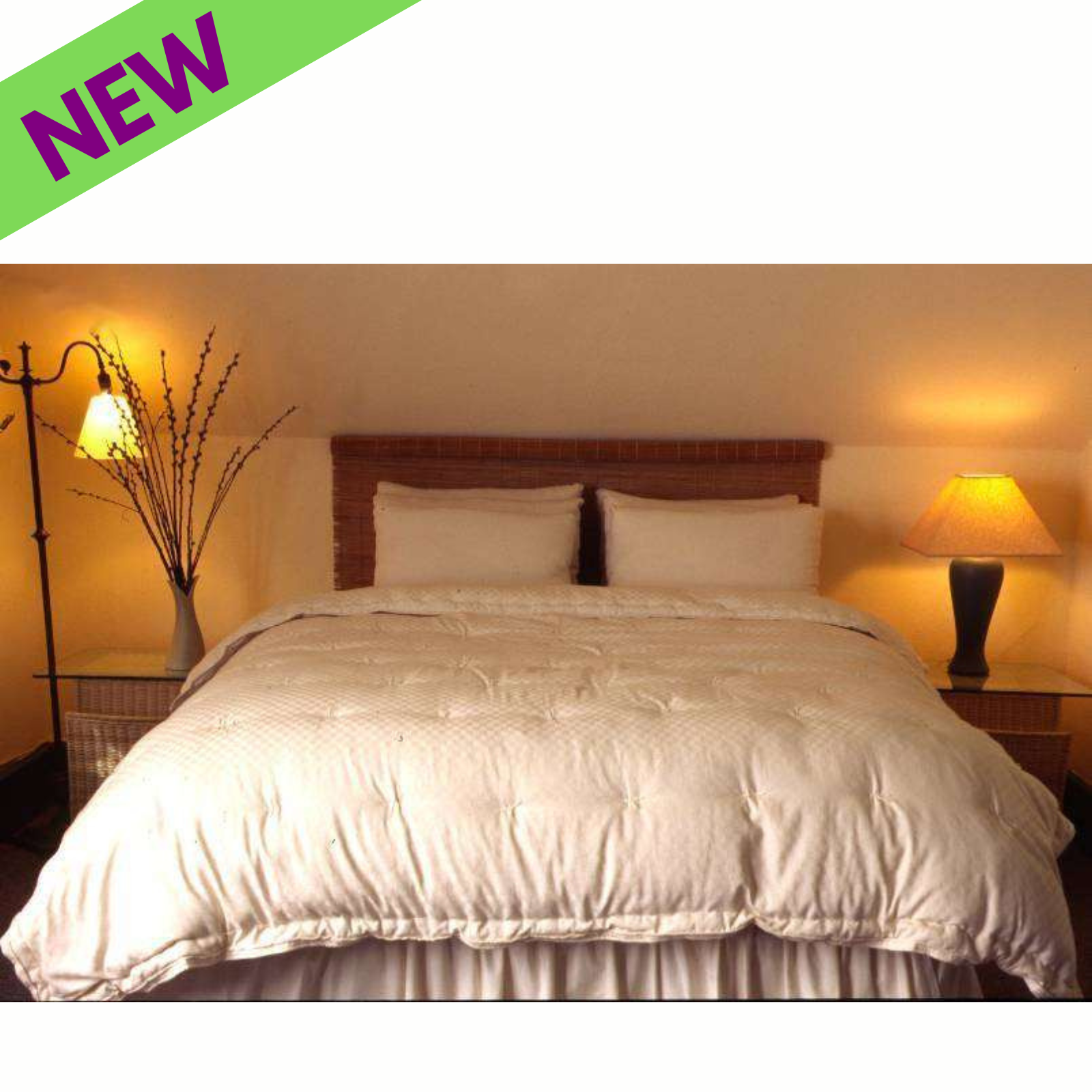 Holy Lamb Organics Comforter on a neatly made bed, showcasing a cozy bedroom setup with lamps and decorative plant.