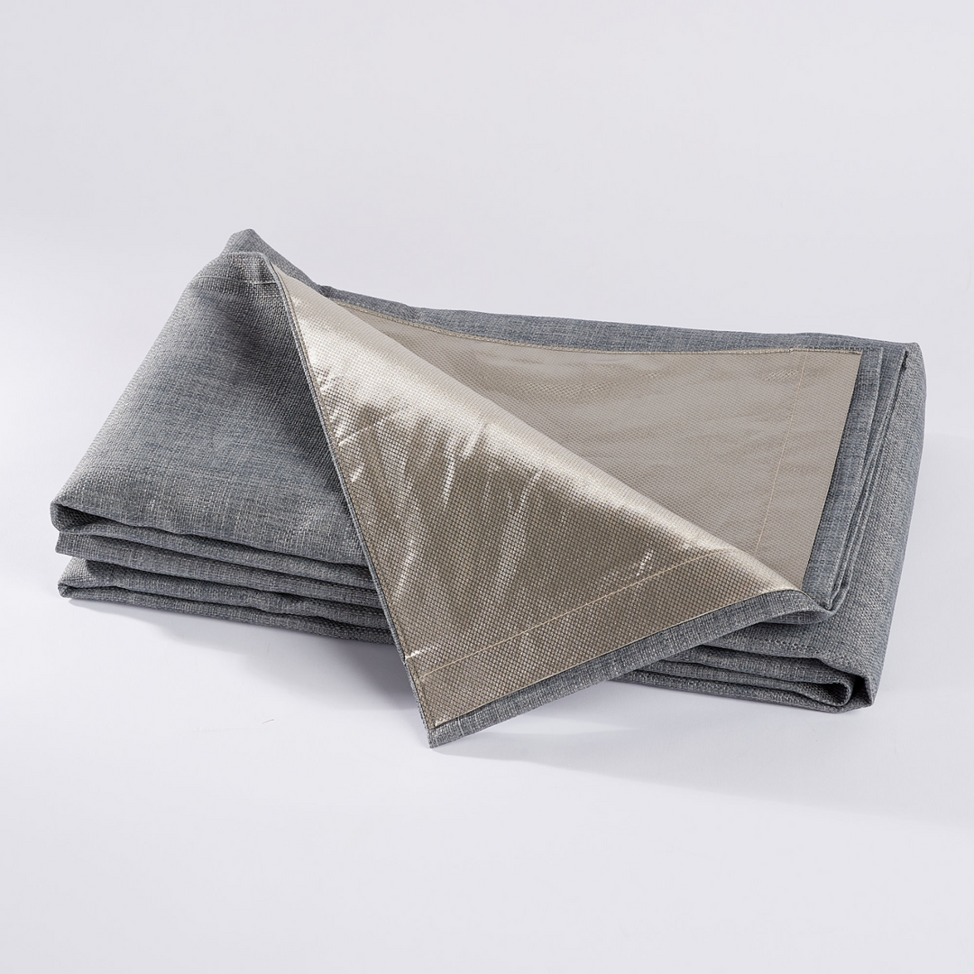Faraday MAX Blackout CYBER Faraday RF EMF Shielding Curtains folded on a surface, showcasing gray fabric with a metallic lining.