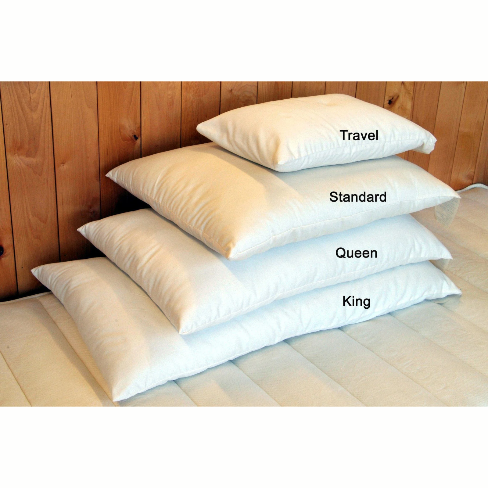 Image showing Holy Lamb Organics Wool Bed Pillows in Travel, Standard, Queen, and King sizes on a bed.
