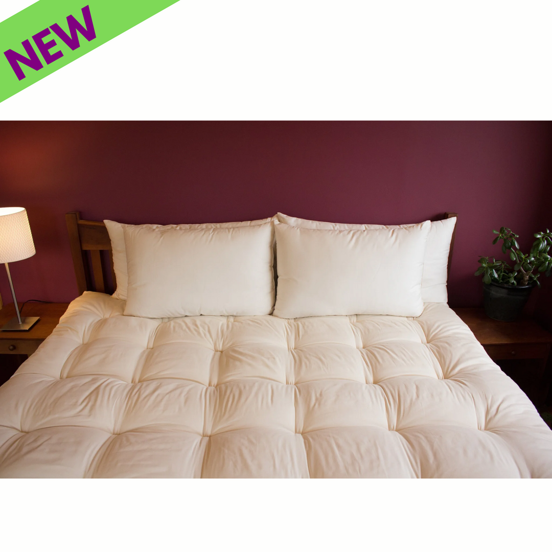 Holy Lamb Organics Wool Bed Pillows on a king-size bed with new mattress topper.
