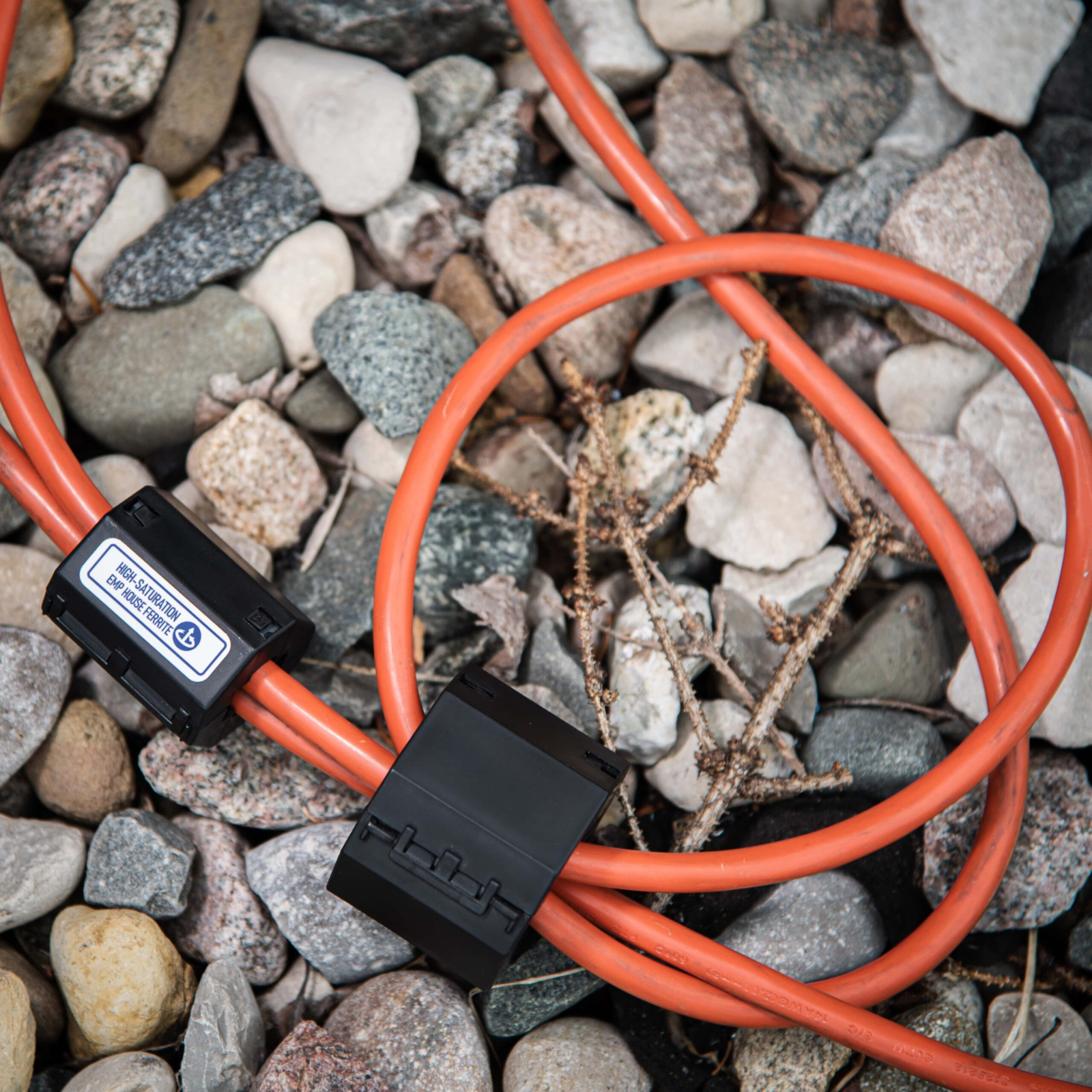 Faraday Broadband EMP Ferrite cables laying on rocks for high frequency noise suppression