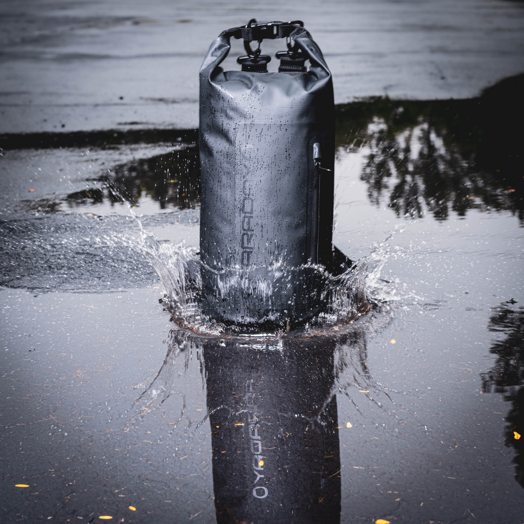 Faraday Dry Bag Sling Pack 10L splashing in water showcasing waterproof features.