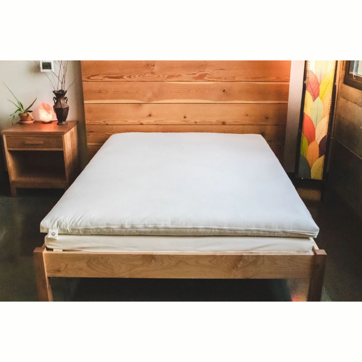 Holy Lamb Natural Wool Latex Shikibuton Mattress on a wooden bed frame in a cozy bedroom setting.