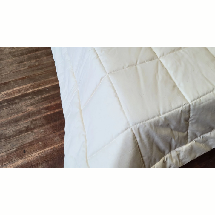 Soaring Heart Quilted Cotton Comforter detail showing soft breathable fabric on a wooden surface.