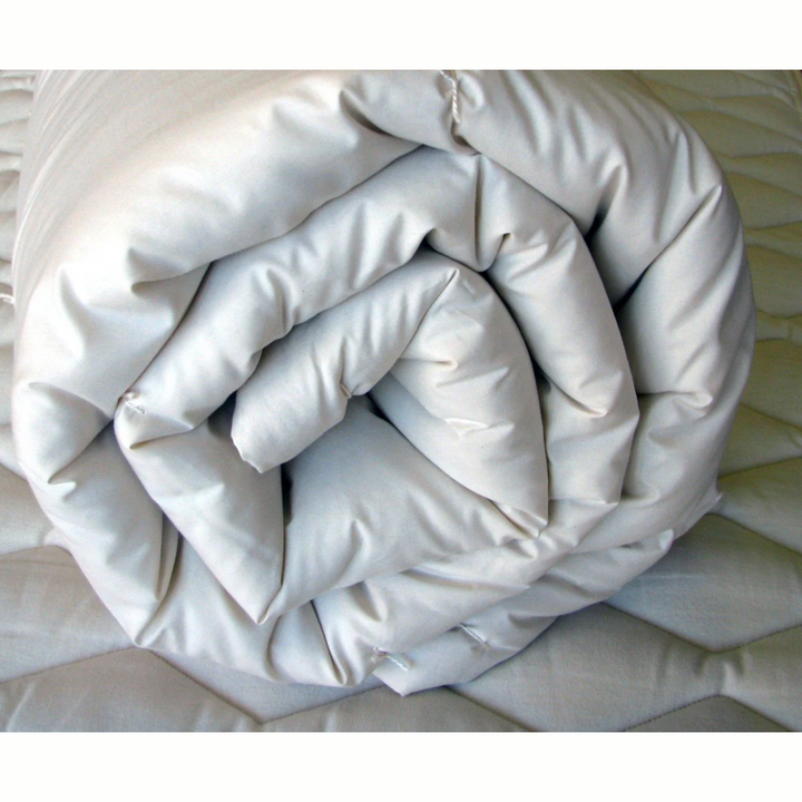 Holy Lamb Wool Comforter rolled and ready for use, showcasing its organic materials and plush design.