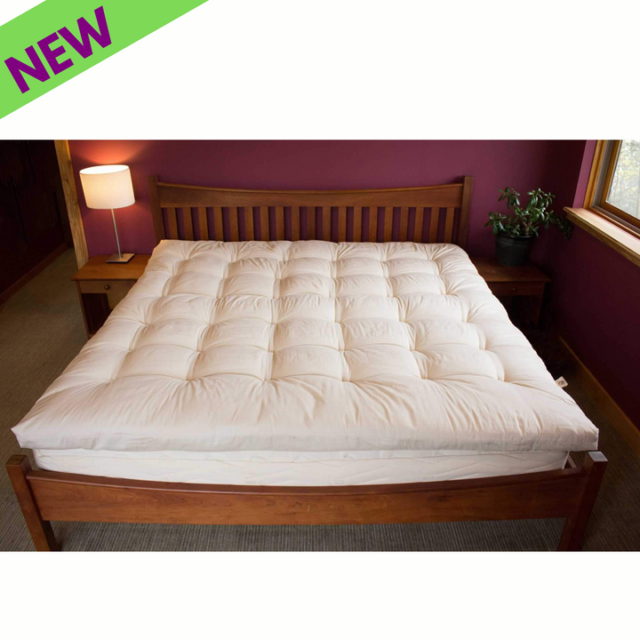 Holy Lamb Quilted Topper Cal King Size on a wooden bed with lamp and plant.