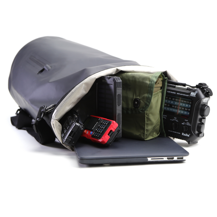 Faraday Dry Bag Sling Pack with electronics and laptop inside, showcasing its waterproof and spacious design.