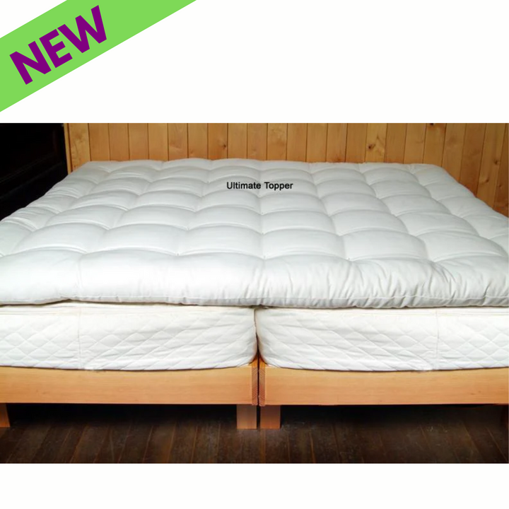 Holy Lamb Organics Quilted Mattress Topper Ultimate CAL King on a wooden bed frame with a new label