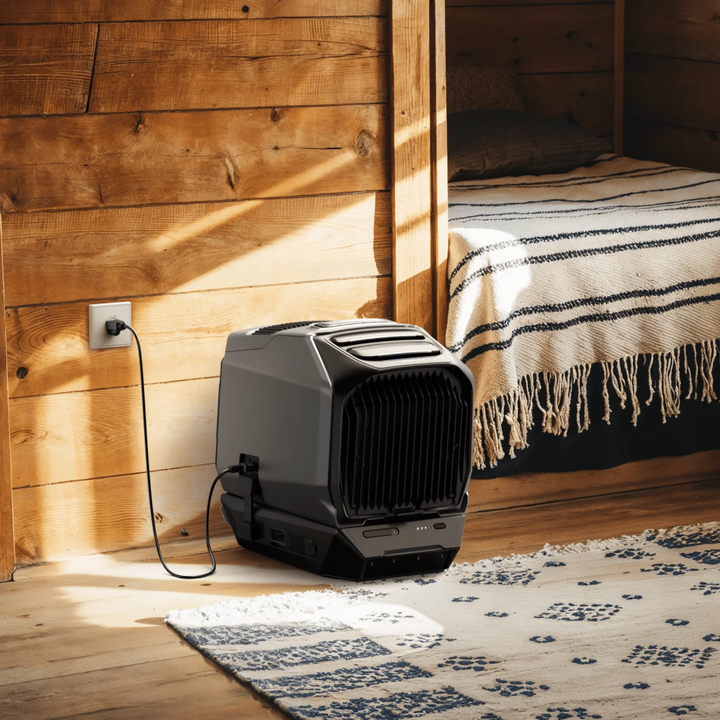 EcoFlow WAVE 3 Portable Cools &amp; Heats unit in a cozy room, plugged into the wall for power.