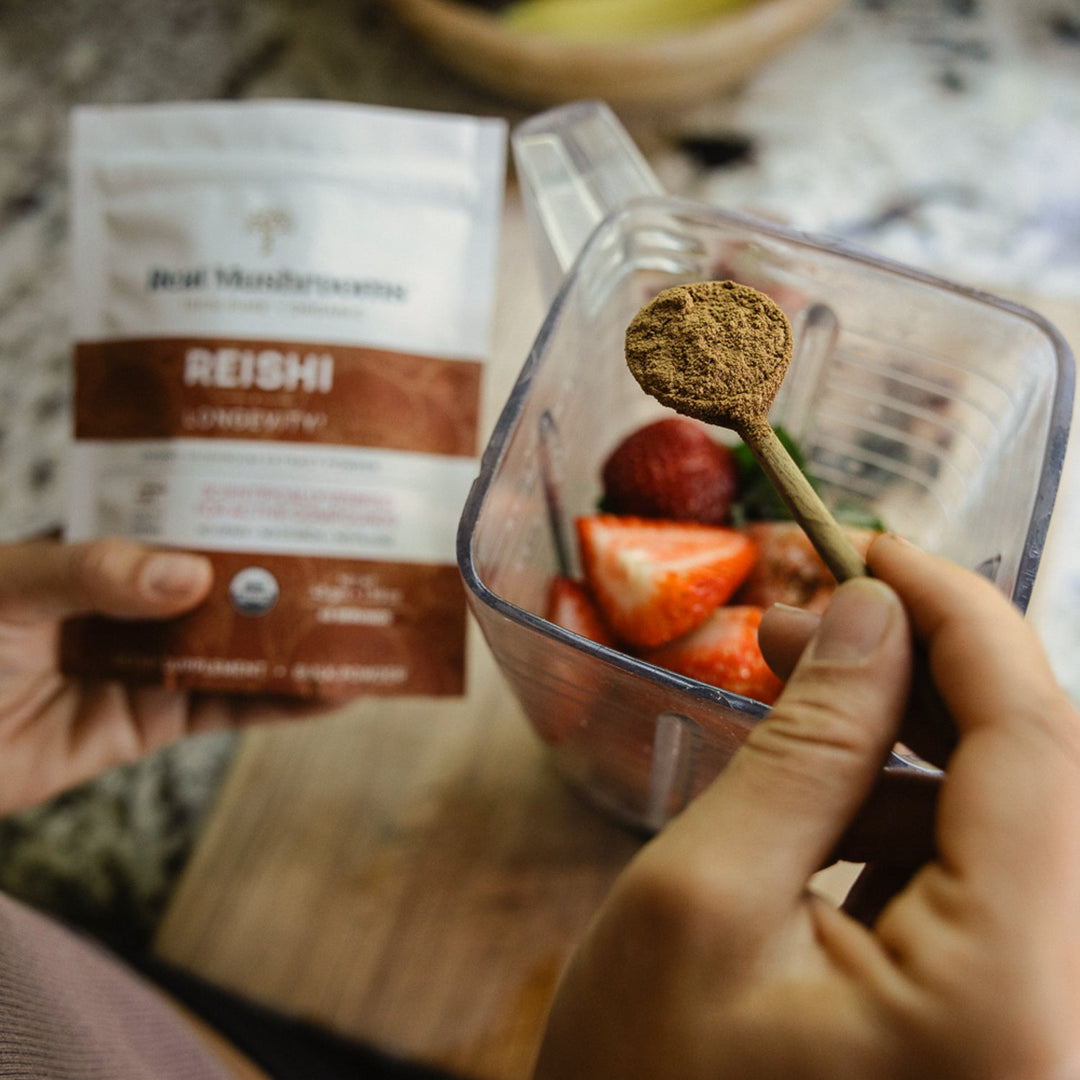 Real Mushrooms Reishi Mushroom Extract used in smoothie preparation with strawberries.