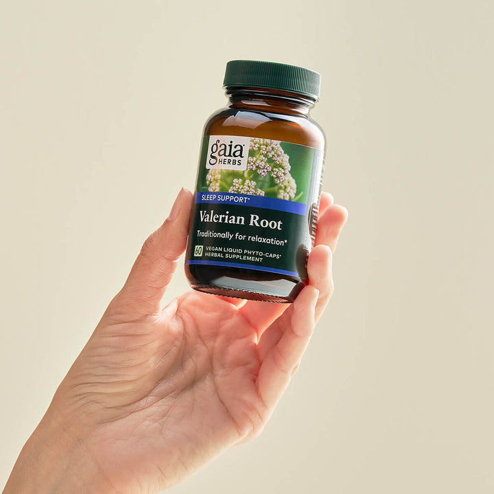 Gaia Herbs Pro Valerian Restful Sleep Support 60 Liquid Phyto Caps in a hand with focus on Valerian Root for relaxation.