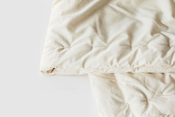 Holy Lamb Organics Wool Comforter, organic cream-colored comforter with soft fabric, perfect for queen-sized beds.