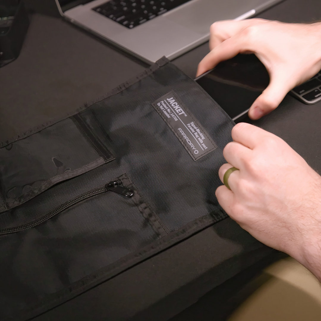 Faraday JACKET Pro Window Port Bag being used to protect a mobile device from signals in a home office setup.