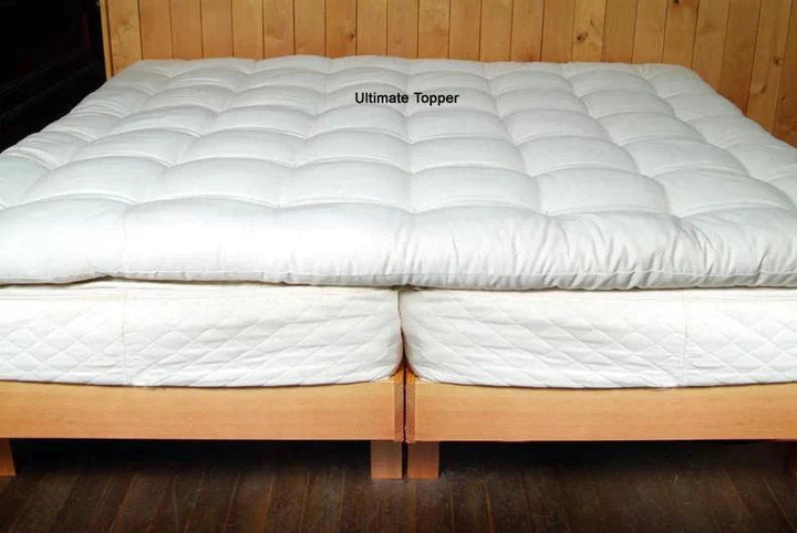 Holy Lamb Organics Quilted Mattress Topper on a bed, showcasing its comfort for deep sleep.