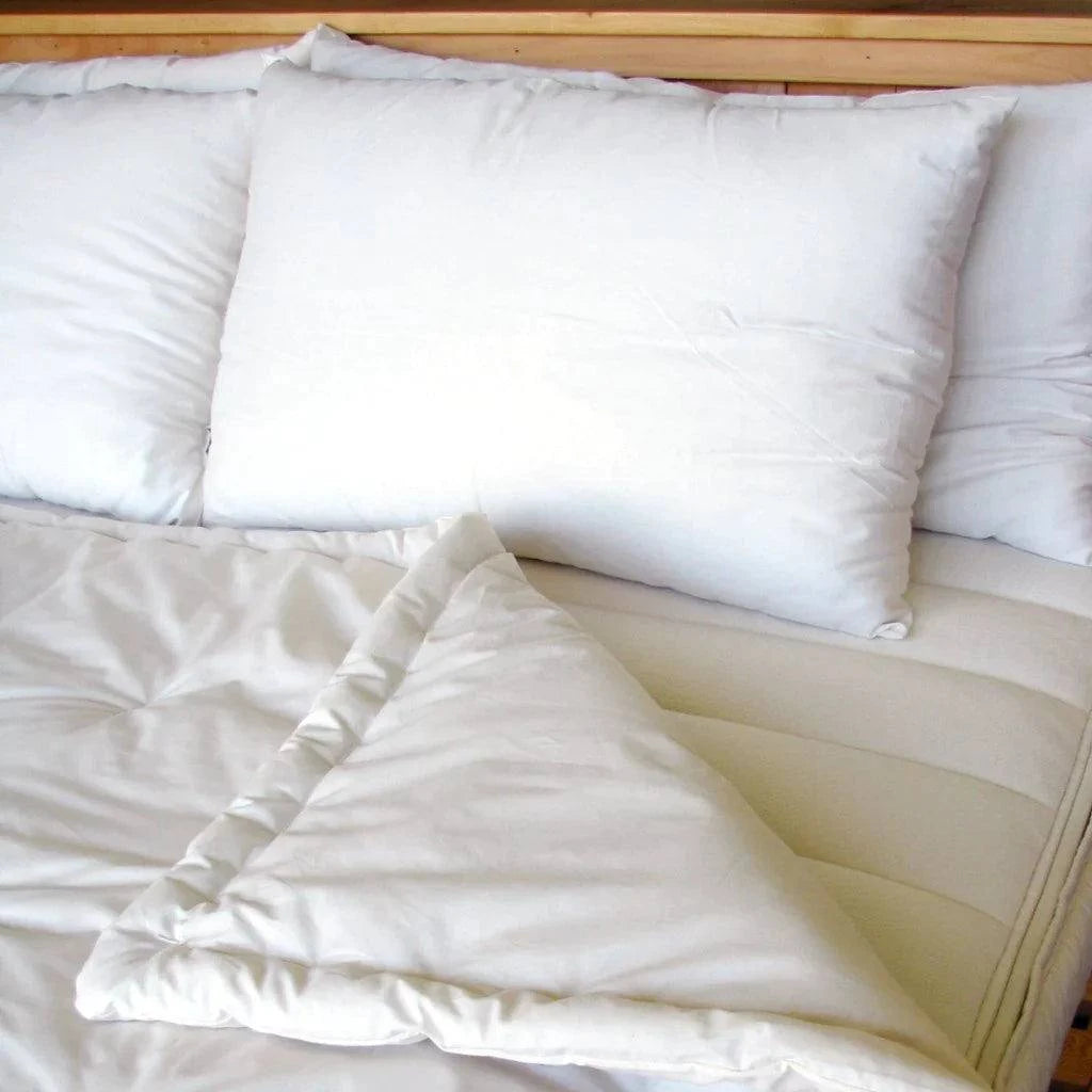Holy Lamb Organics Comforter with pillows on a bed, showcasing premium organic wool comfort for king size beds.