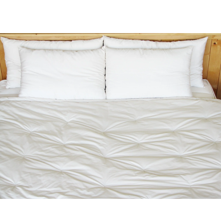 Holy Lamb Organics Comforter laid over a bed with white pillows, showcasing its soft texture and extra warmth for a twin bed.