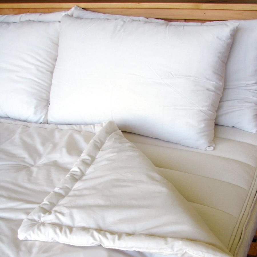 Holy Lamb Organics Comforter on bed with fluffy pillows, showcasing organic comfort and extra warmth.