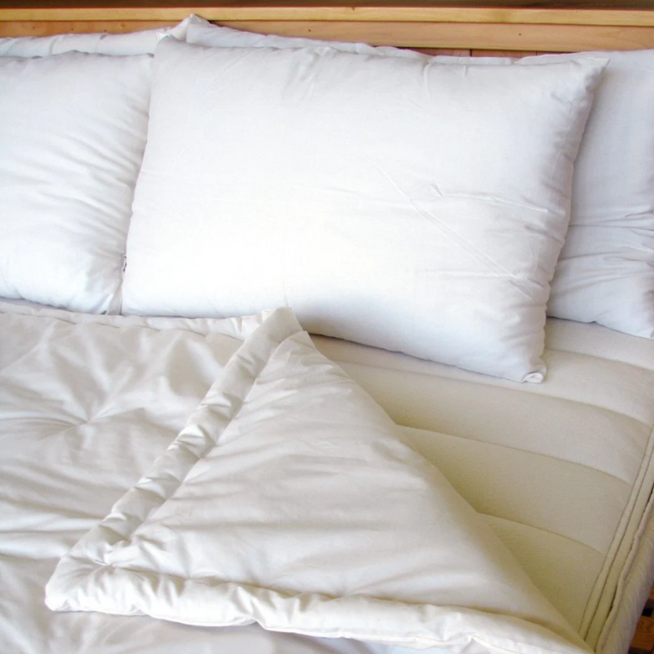 Holy Lamb Organics Comforter on bed with fluffy pillows, showcasing organic comfort and extra warmth.